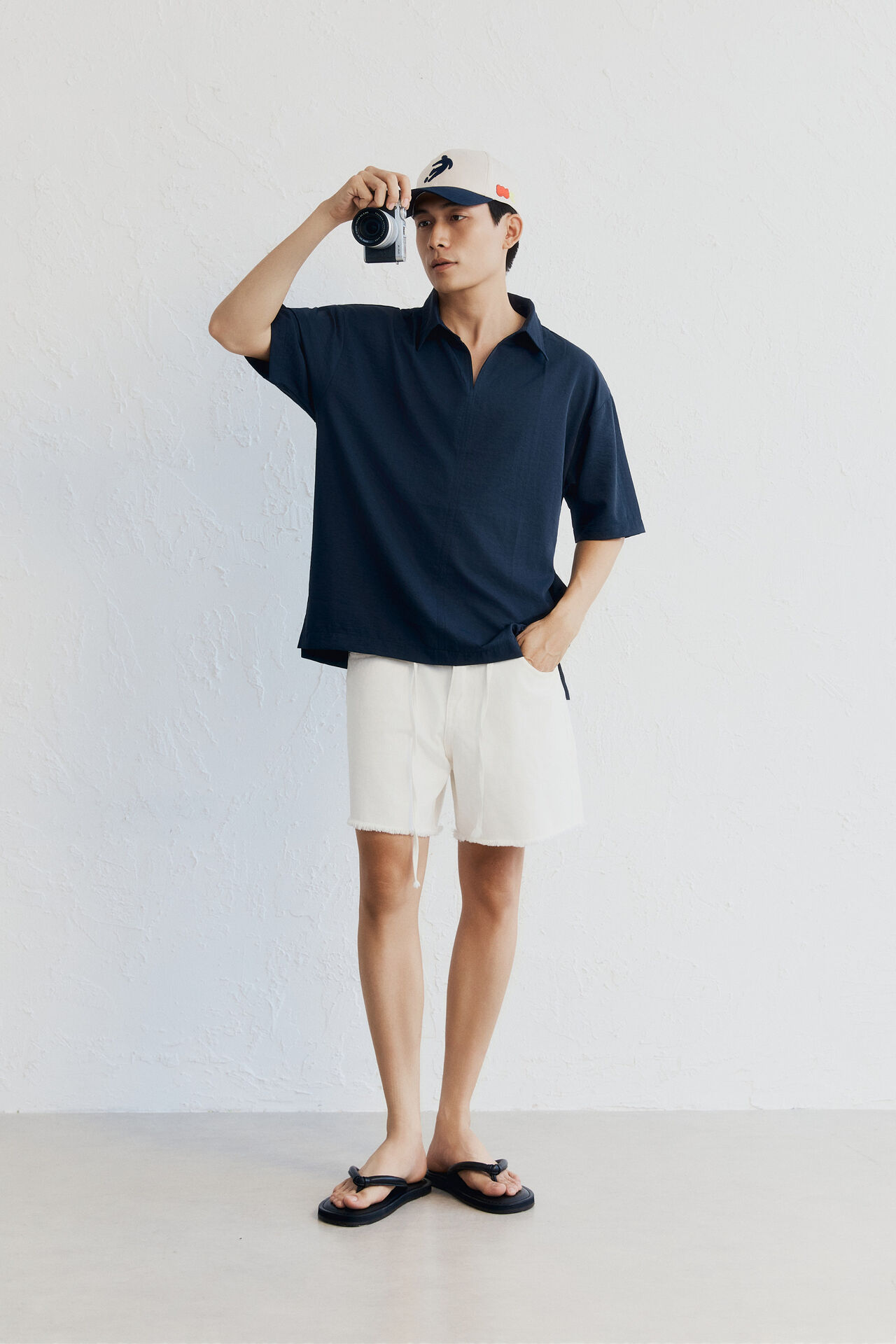 Áo polo navy ngắn tay, quần short trắng, mũ lưỡi trai